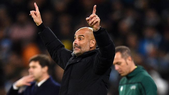 Gestur manajer Manchester City, Pep Guardiola pada laga Liga Champions kontra Paris Saint-Germain di Etihad Stadium, Manchester, Kamis (25/11/2021) dini hari WIB. [Oli SCARFF / AFP]