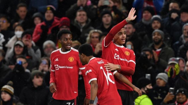 Striker Manchester United asal Inggris, Mason Greenwood (kanan) melakukan selebrasi dengan rekan satu timnya setelah mencetak gol dalam laga terakhir Grup F Liga Champions antara Man United vs Young Boys di Old Trafford, Manchester, Kamis (9/12/2021) dini hari WIB.Paul ELLIS / AFP.