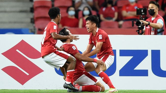 Pemain Indonesia Ezra Harm Ruud Walian (tengah) diberi selamat oleh rekan setimnya setelah mencetak gol pada pertandingan leg kedua semifinal sepak bola AFF Suzuki Cup 2020 antara Singapura dan Indonesia di National Stadium di Singapura pada 25 Desember 2021.  Roslan RAHMAN / AFP