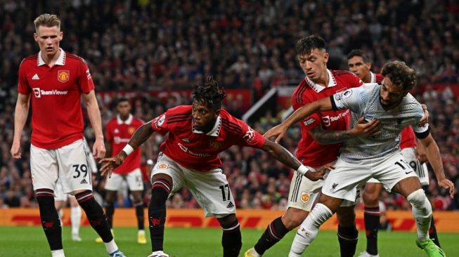 Gelandang Manchester United asal Brasil Fred (tengah) coba memberikan operan kepada rekannya dalam laga pekan ketiga Liga Inggris 2022/2023 antara Manchester United vs Liverpool di Old Trafford, Manchester, pada 22 Agustus 2022.Paul ELLIS / AFP.