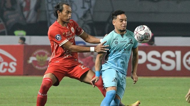 Pesepak bola Madura United FC Luiz Marcelo (kanan) dihadang pesepak bola Persija Jakarta Hansamu Yama (kiri) pada pertandingan Liga 1 di Stadion Patriot Chandrabhaga, Bekasi, Jawa Barat, Sabtu (17/9/2022). ANTARA FOTO/ Fakhri Hermansyah/aww.