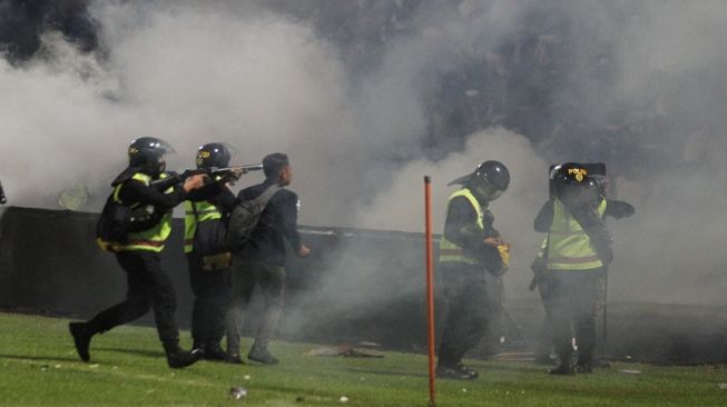 Aparat keamanan menembakkan gas air mata untuk menghalau suporter yang masuk lapangan usai pertandingan sepak bola BRI Liga 1 antara Arema melawan Persebaya di Stadion Kanjuruhan, Malang, Sabtu (1/10/2022). ANTARA FOTO/Ari Bowo Sucipto/tom. 