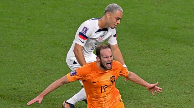 Bek Timnas Belanda #17 Daley Blind melakukan selebrasi dihadapan bek AS #02 Sergino Dest setelah mencetak gol kedua timnya selama pertandingan babak 16 besar Piala Dunia 2022 antara Belanda vs Amerika Serikat di Stadion Internasional Khalifa di Doha pada 3 Desember 2022.Raúl ARBOLEDA / AFP