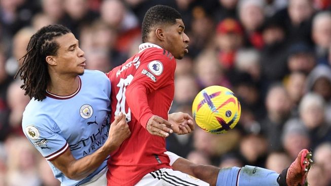 Bek Manchester City Nathan Ake (kiri) bersaing dengan striker Manchester United Marcus Rashford selama pertandingan pekan ke-20 Liga Inggris antara Manchester United vs Manchester City di Old Trafford di Manchester, barat laut Inggris, pada 14 Januari 2023.Oli SCARFF/AFP