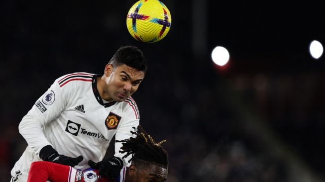 Gelandang Manchester United, Casemiro (kiri) melakukan duel udara pada laga Liga Inggris kontra Crystal Palace di Selhurst Park, London, Kamis (19/1/2023) dini hari WIB. [ADRIAN DENNIS / AFP]