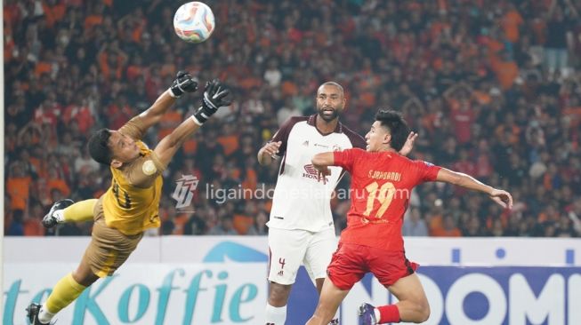 Kiper PSM Makassar, Muhammad Reza Pratama coba menepis bola hasil sundulan gelandang Persija Jakarta Hanif Sjahbandi selama pertandingan pekan pertama BRI Liga 1 2023-2024 antara Persija vs PSM Makassar di Stadion Utama Gelora Bung Karno (SUGBK), Jakarta, Senin (3/7/2023) malam WIB. [Liga Indonesia Baru]