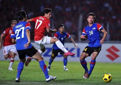 Striker Timnas Indonesia, Irfan Bachdim, duel dengan pemain Timnas Malaysia, Mochamad Muslim (R) dan Mochamad Fadli (2L) selama final leg kedua AFF Suzuki Cup 2010 pada 29 Desember 2010, di Jakarta. (AFP/ ADEK BERRY).