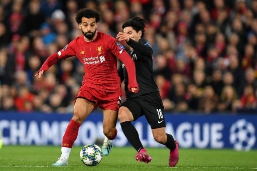 Pemain Salzburg asal Jepang Takumi Minamino berebut bola dengan pemain Liverpool Mohamed Salah di fase grup Liga Champions yang digelar di Anfield pada 22 Oktober 2019. [AFP]