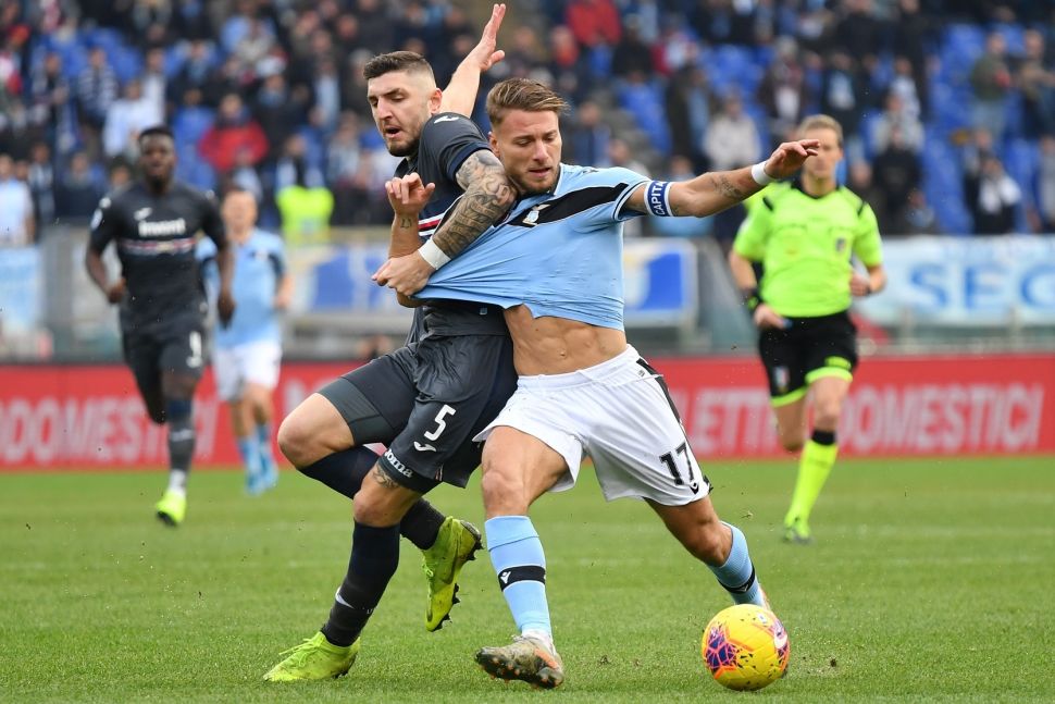 Penyerang Lazio, Ciro Immobile, saat dijaga ketat oleh bek Sampdoria, Julian Chabot (kiri), dalam lanjutan laga Liga Italia Serie A, Sabtu (18/1/2020). [Alberto PIZZOLI / AFP]